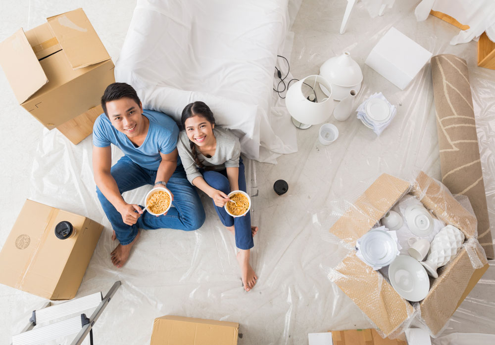 Asian couple unpacking in new home