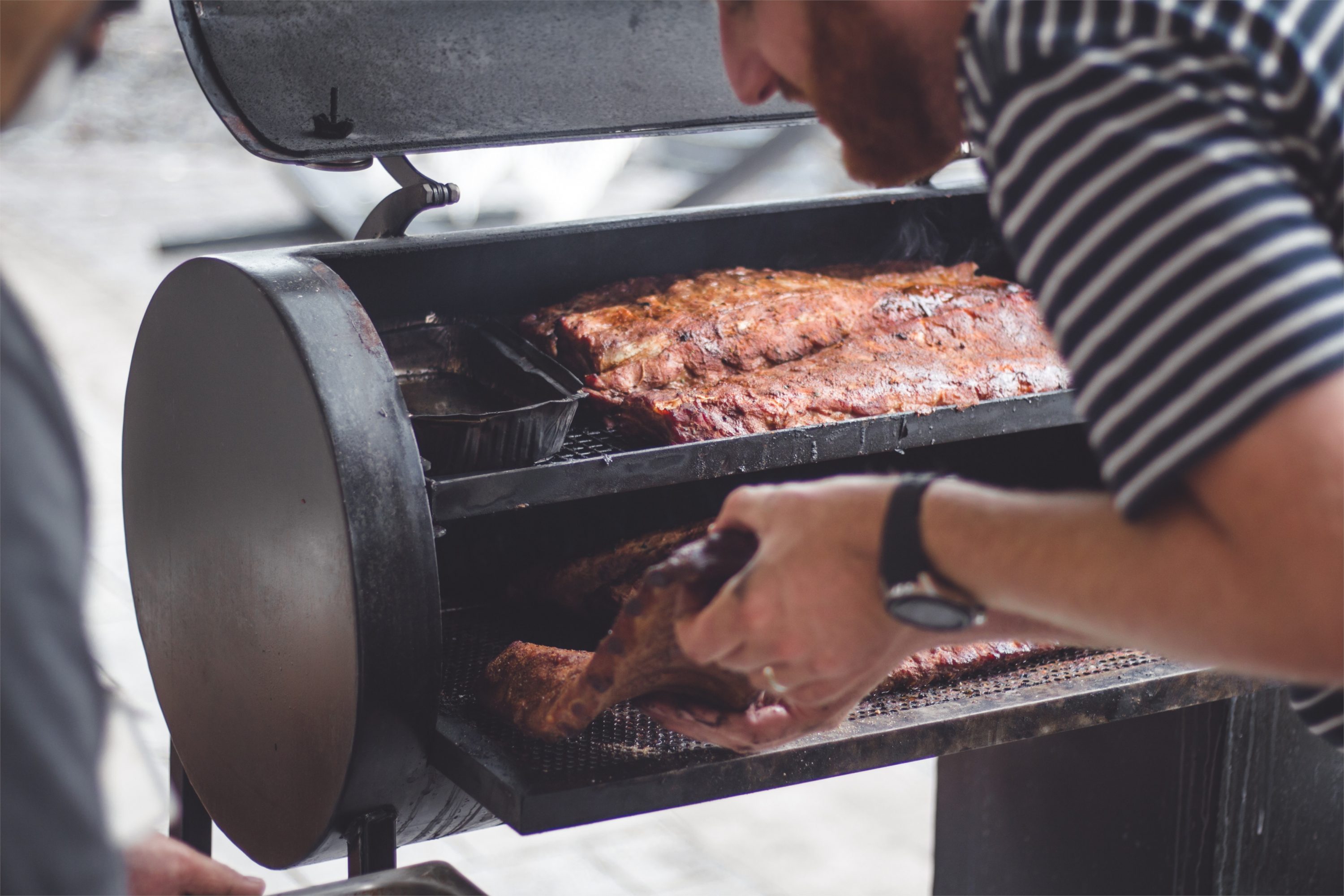 man smokes ribs