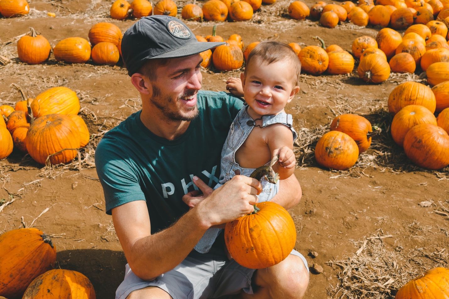 man with child at pumpkin patch