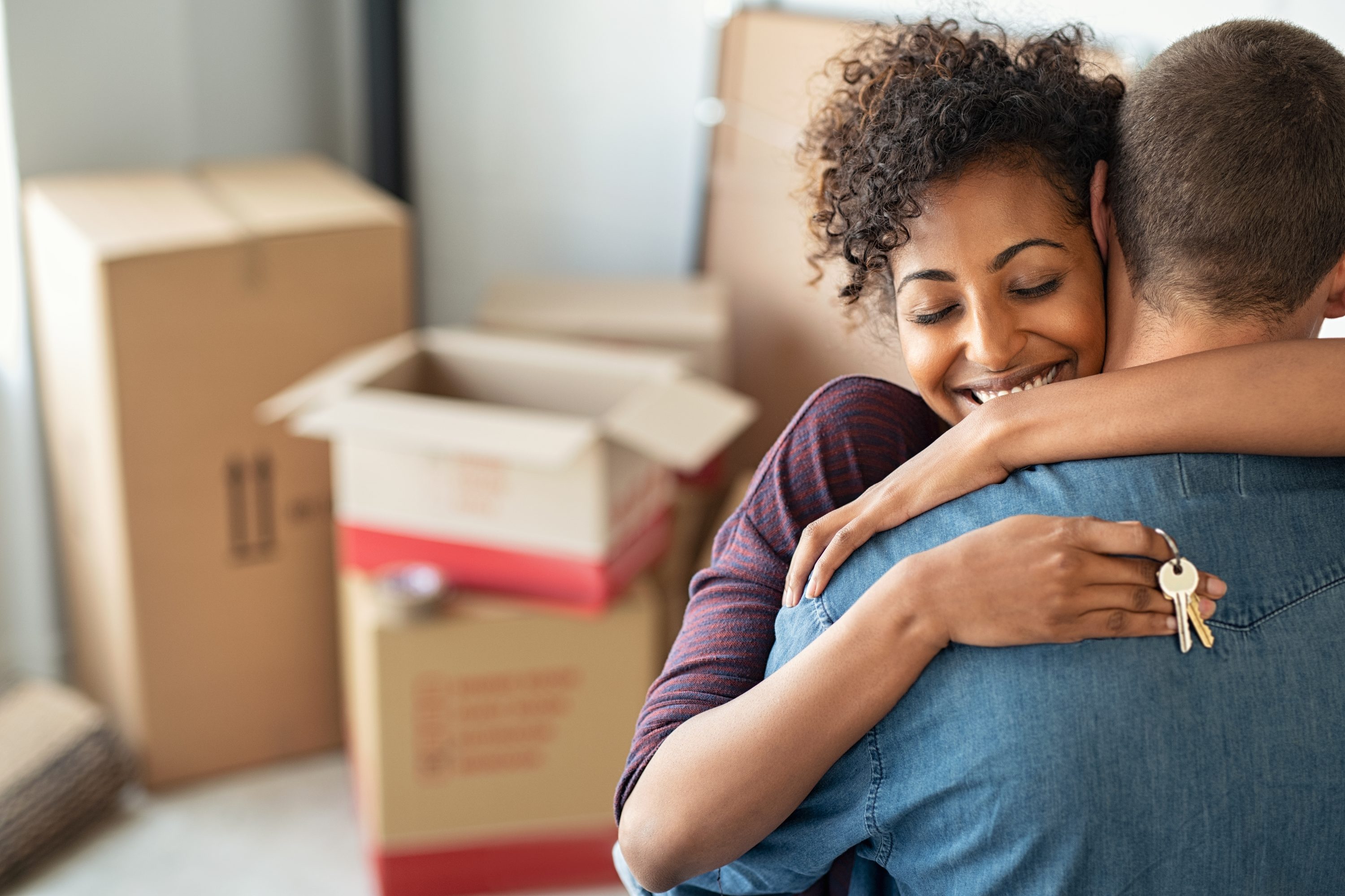 couple hugging in front of packing boxes