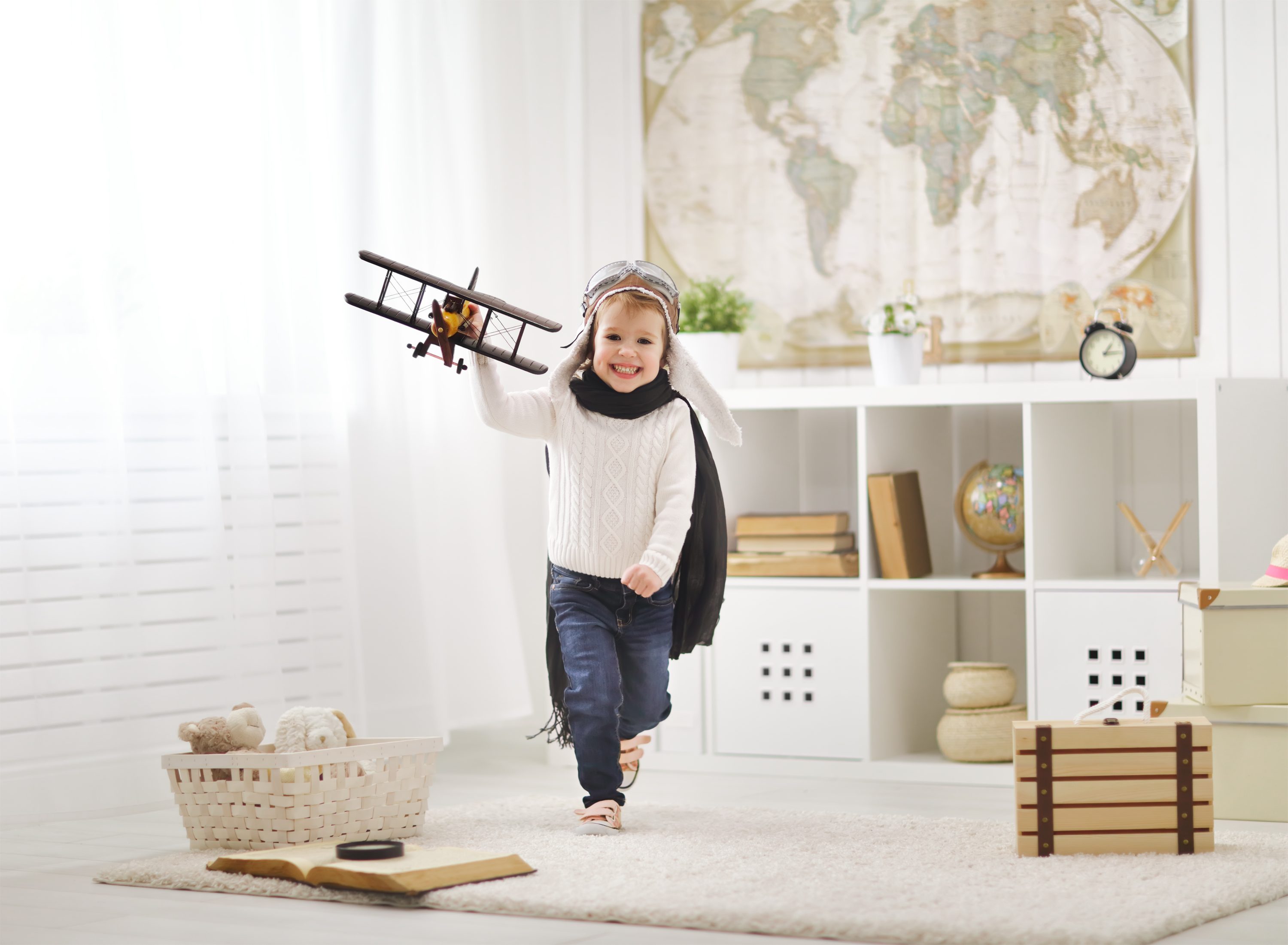 child flying toy airplane in playroom